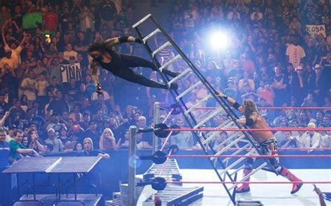 Edge pushing The Undertaker off of a ladder through some tables.
